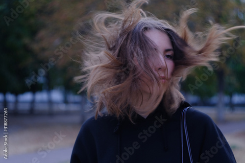 Serious look of girl with windy hair at dark street