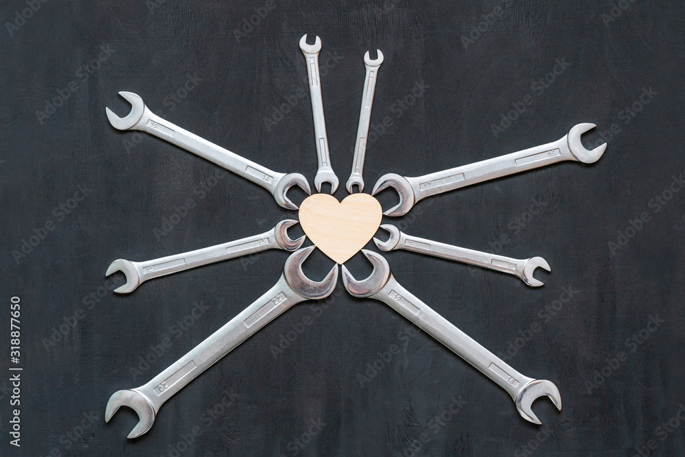 Heart clamped in vise of mechanic wrenches spanners on black background. Industrial creative concept of check and mend a car motor in service station. Symbol of health. Heart clamped in vise of mechanic wrenches spanners on black background. Industrial creative concept of check and mend a car motor in service station. Symbol of health.