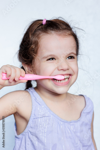 Adorable child girl cleaning teath by toothbrush.