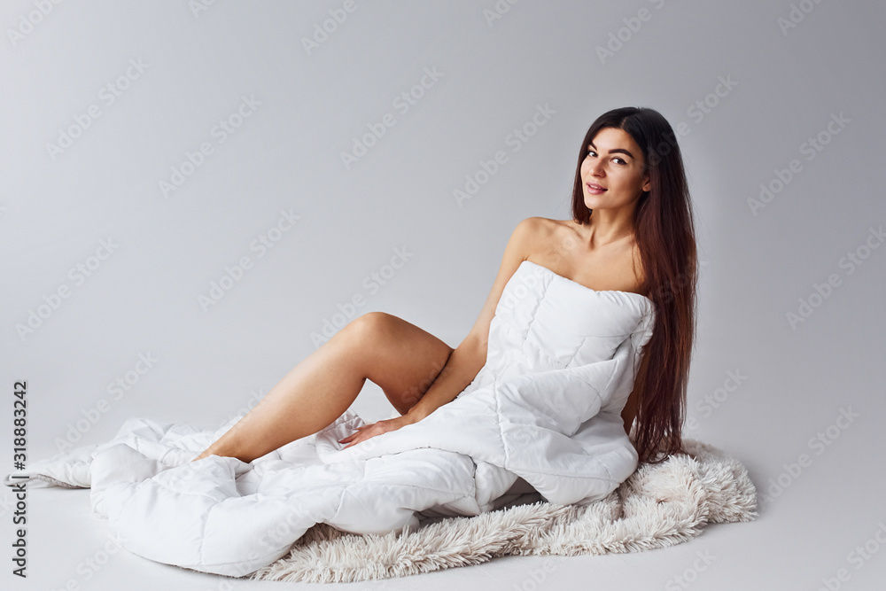 Woman in underwear sits in the studio against white background Woman in underwear sits in the studio against white background