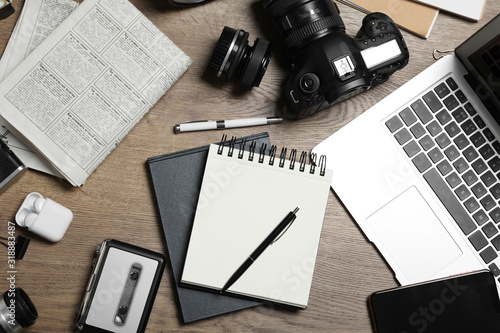 Flat lay composition with equipment for journalist on wooden table photo