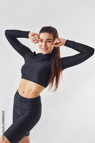 Sportive woman in black clothes in the studio against white background © standret