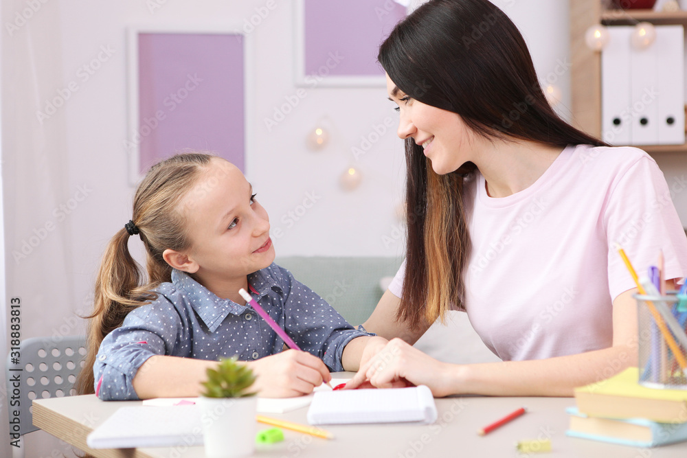 Mom helps the girl to do homework. Children and parents. Mom helps the girl to do homework. Children and parents.