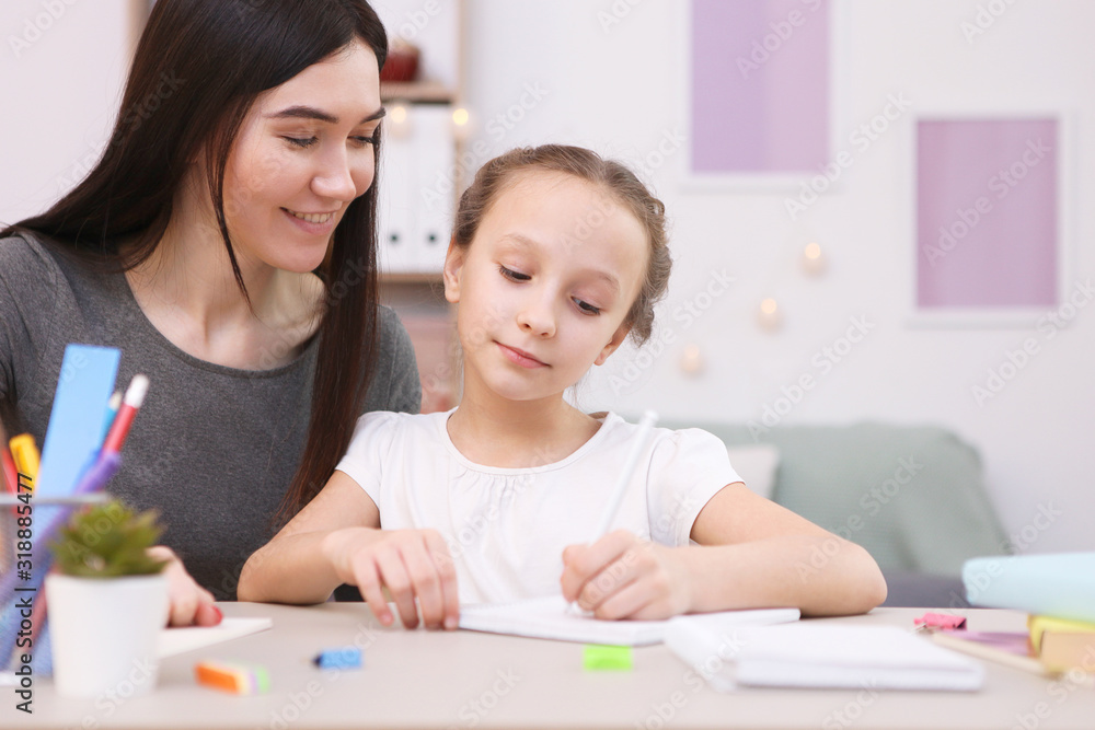 Mom helps the girl to do homework. Children and parents. Mom helps the girl to do homework. Children and parents.