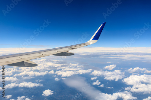 Airplane wing and beautiful blue sky with white clouds