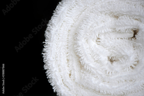 Clean white towel rolled blanket textile close up on black background