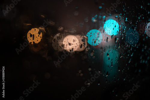 glare on wet glass at night. raindrops on the window. city lights at night.