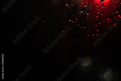 glare on wet glass at night. raindrops on the window. city lights at night.
