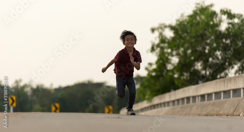 A little boy runs along the bridge.
