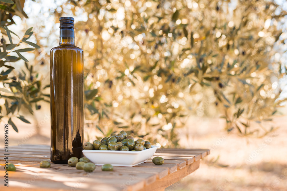 green olives and oil on table in olive grove green olives and oil on table in olive grove