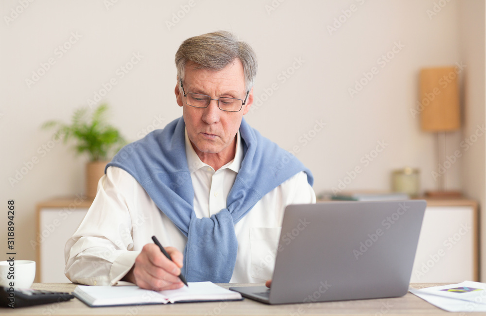 Mature Man At Laptop Working Taking Notes Sitting In Office Mature Man At Laptop Working Taking Notes Sitting In Office