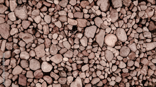 Red and brown stones on the sea coast. Pebbles lying on the beach.Wall of small stones.