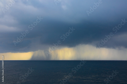 Rain & storms over the ocean, on a grey clound day at sea. © lisastrachan
