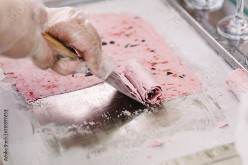 Preparation of natural berry ice cream right during the holiday. Cook rolls ready ice cream into a roll. Selective focus