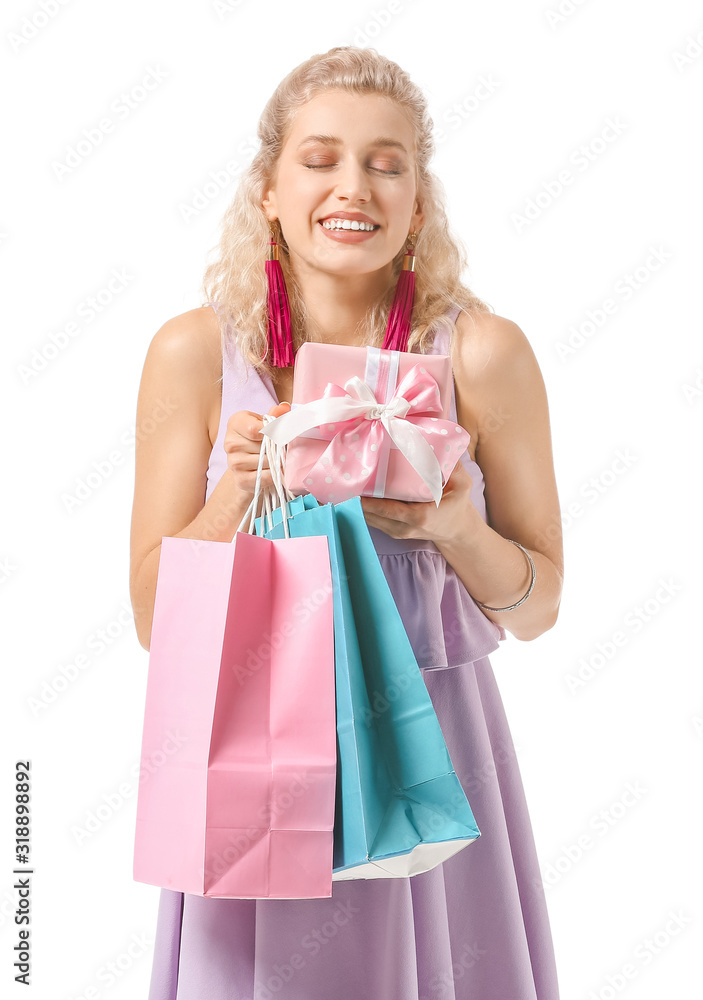 Beautiful young woman with gift and shopping bags on white background. International Women's Day celebration