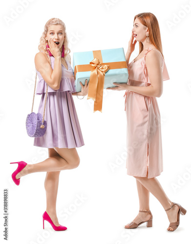 Beautiful young women with big gift on white background. International Women's Day celebration