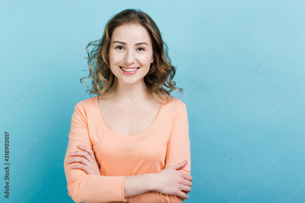 Happy pretty woman standing with folded hands wearing casual clothes over blue background Happy pretty woman standing with folded hands wearing casual clothes over blue background
