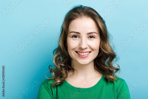 Closeup portrait of pretty smiling curly woman wearing in green sweater