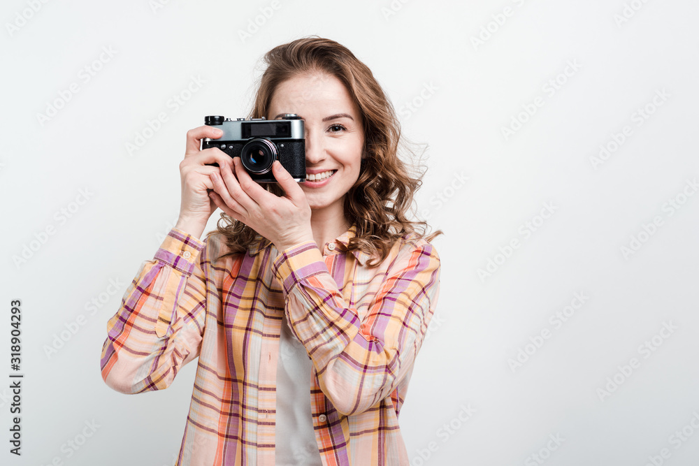 Portrait of a happy girl using retro camera over white studio background Portrait of a happy girl using retro camera over white studio background