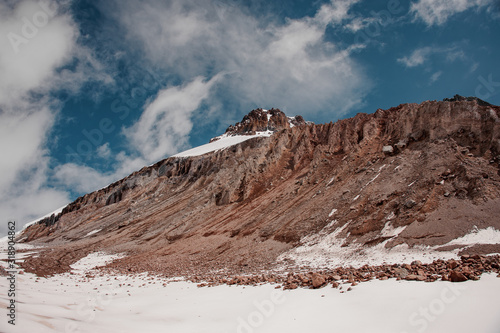 Smooth mountain slope covered in snow under cloudy sky photo