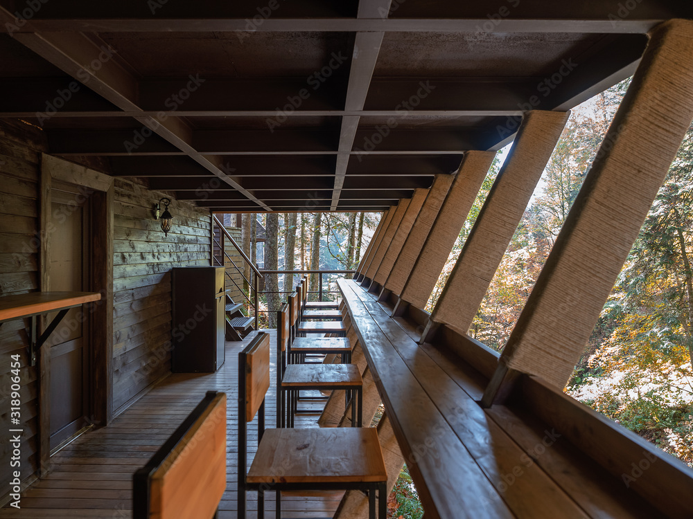 Obraz premium The balcony of the forest cafe is made of wood with wooden furniture. Inside view