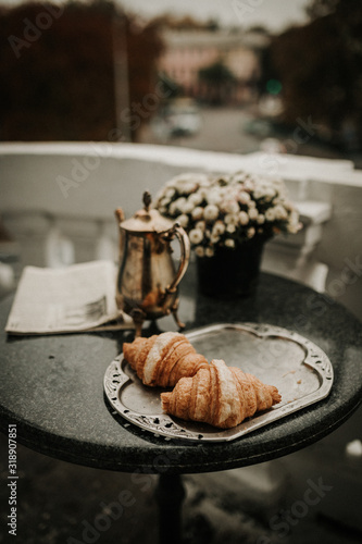 Breakfast with croissants and coffee served on a beautiful terrace or balcony