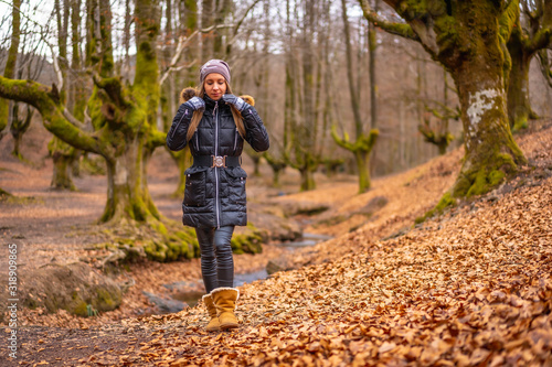 Very happy blonde girl in a beautiful forest walking among leaves © unai