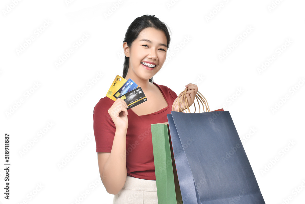 Beautiful Asian woman wearing braces are holding up a credit card and shopping bag happily. Beautiful Asian woman wearing braces are holding up a credit card and shopping bag happily.