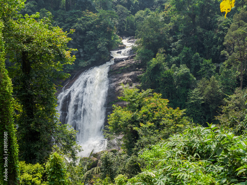 Steep waterfall in indian rainforest jungle in Kerala  South India on sunny day