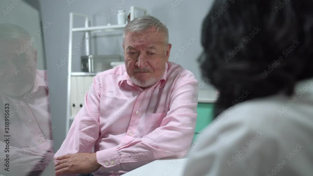 Old man sit in cabinet of hospital and listen to the doctor Old man sit in cabinet of hospital and listen to the doctor