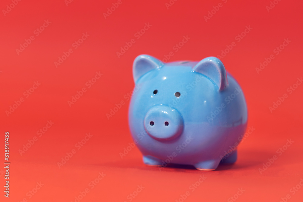 Piggy coin bank on orange background for money savings, financial security or personal funds concept.
