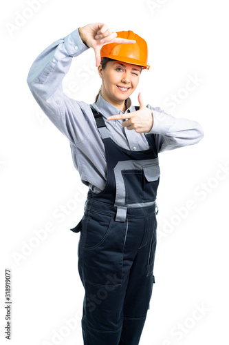 A female construction team leader smiles and takes measurements with hand gestures. Isolated