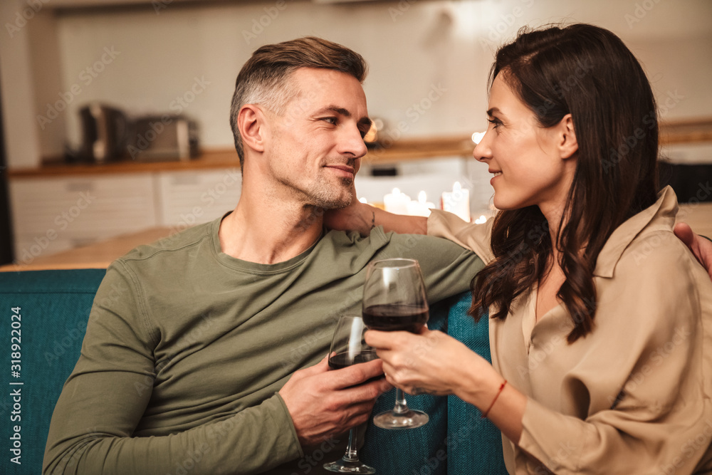 Image of couple drinking red wine while having romantic dinner at home Image of couple drinking red wine while having romantic dinner at home