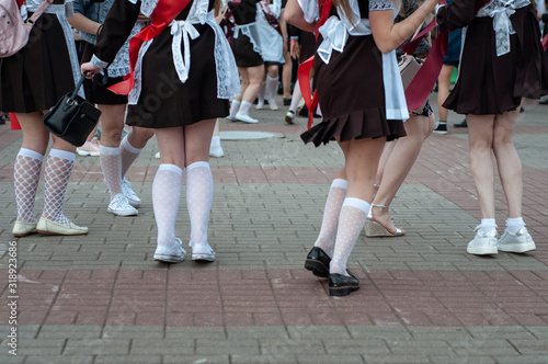 Girls high school graduates in school uniforms are dancing at the graduation parade. Last call.