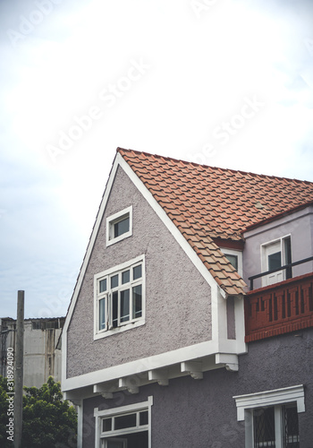 casa con tejado anaranjado en forma triangular con cielo nublado © Bruno