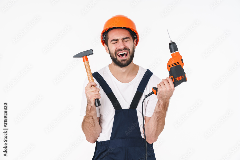 Sad young man holding drill and hammer. Sad young man holding drill and hammer.
