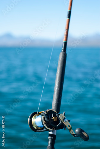 Close up of fishing rod with sea and sky background