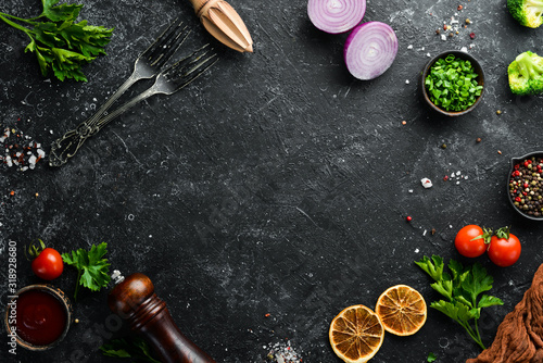 Black food background. Vegetables and spices on black background. Top view. Free space for your text. photo