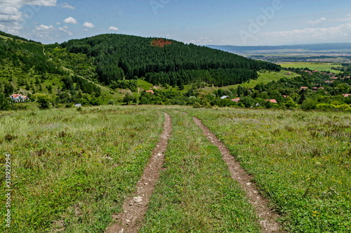 Summer scene with mountain glade, forest and residential district of bulgarian Zhelyava village, Sofia region, Balkan mountain, Bulgaria  photo