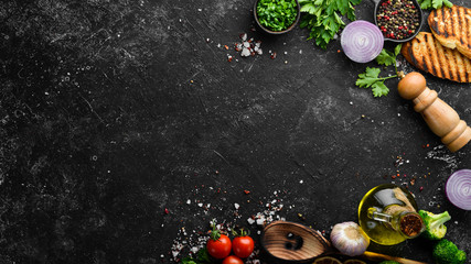 Black food background. Vegetables and spices on black background. Top view. Free space for your text.