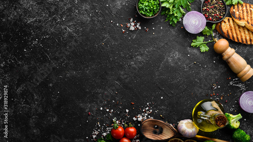 Black food background. Vegetables and spices on black background. Top view. Free space for your text.