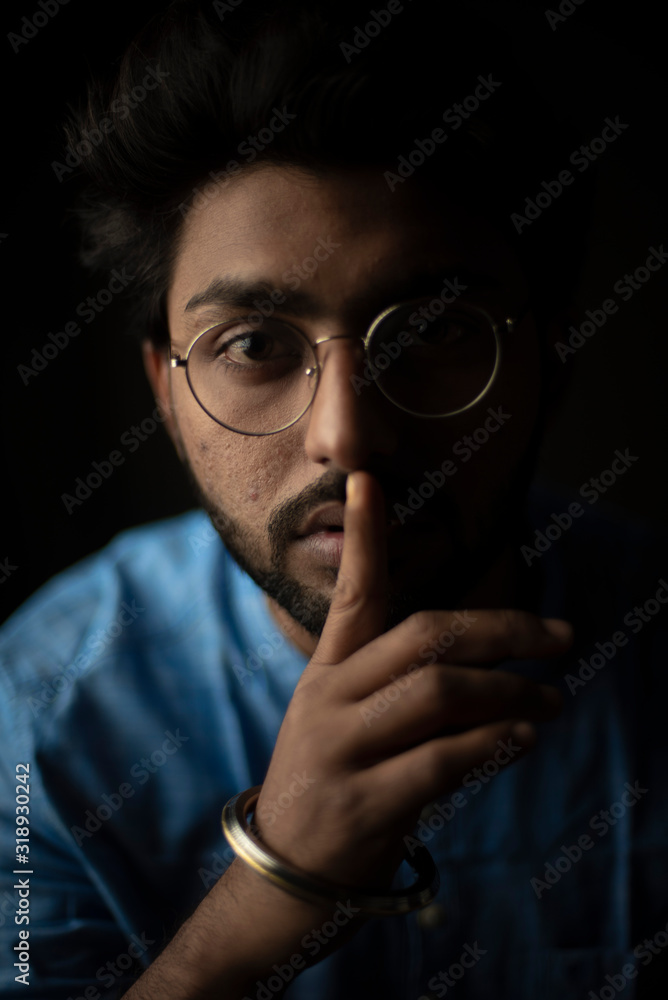 Fashion portrait of young and handsome Indian Bengali brunette man with traditional cotton wear and glasses holding pencil in black copy space background. Indian lifestyle and fashion photograph Fashion portrait of young and handsome Indian Bengali brunette man with traditional cotton wear and glasses holding pencil in black copy space background. Indian lifestyle and fashion photograph