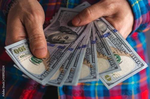 Man hands holding pile of money. pile of one hundred Dollars banknotes in man hands