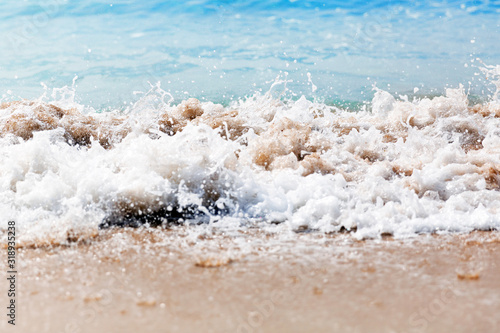 Close up sea waves with splashes on sand beach. Close up