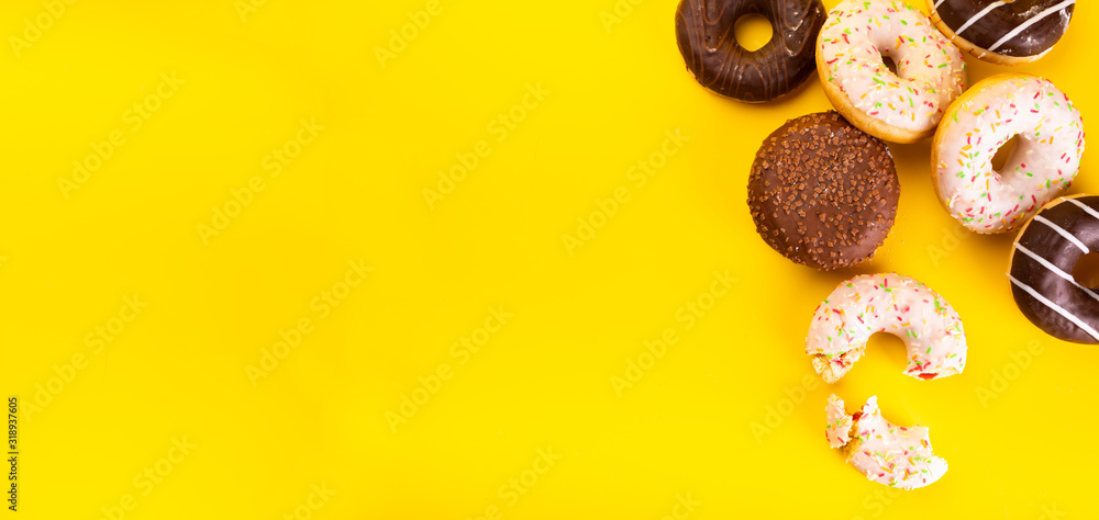 Donuts with various toppings on yellow background. Fat Thursday. Doughnuts Donuts with various toppings on yellow background. Fat Thursday. Doughnuts
