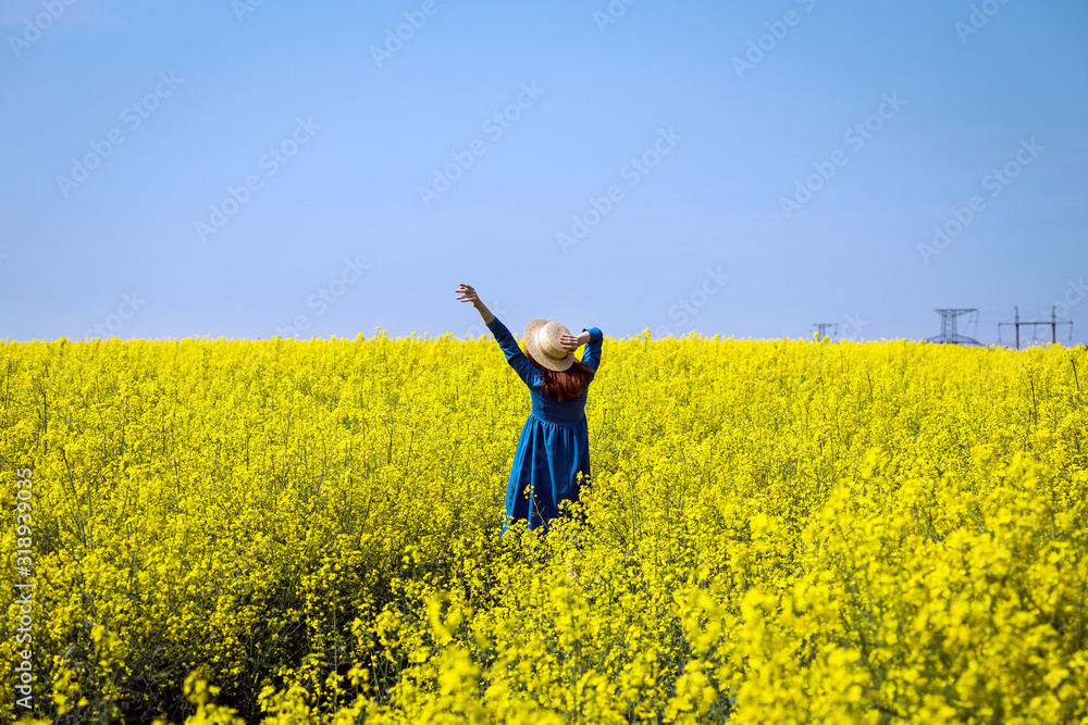 girl walking in a field of yellow rapeseed girl walking in a field of yellow rapeseed