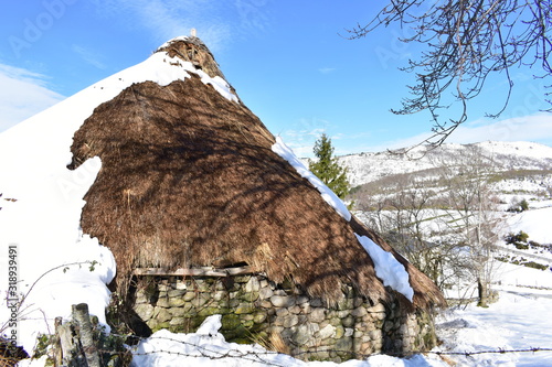 Famous Piornedo mountain village after a snowfall with ancient round Palloza stone houses with thatched roofs. Ancares, Lugo, Galicia, Spain. photo