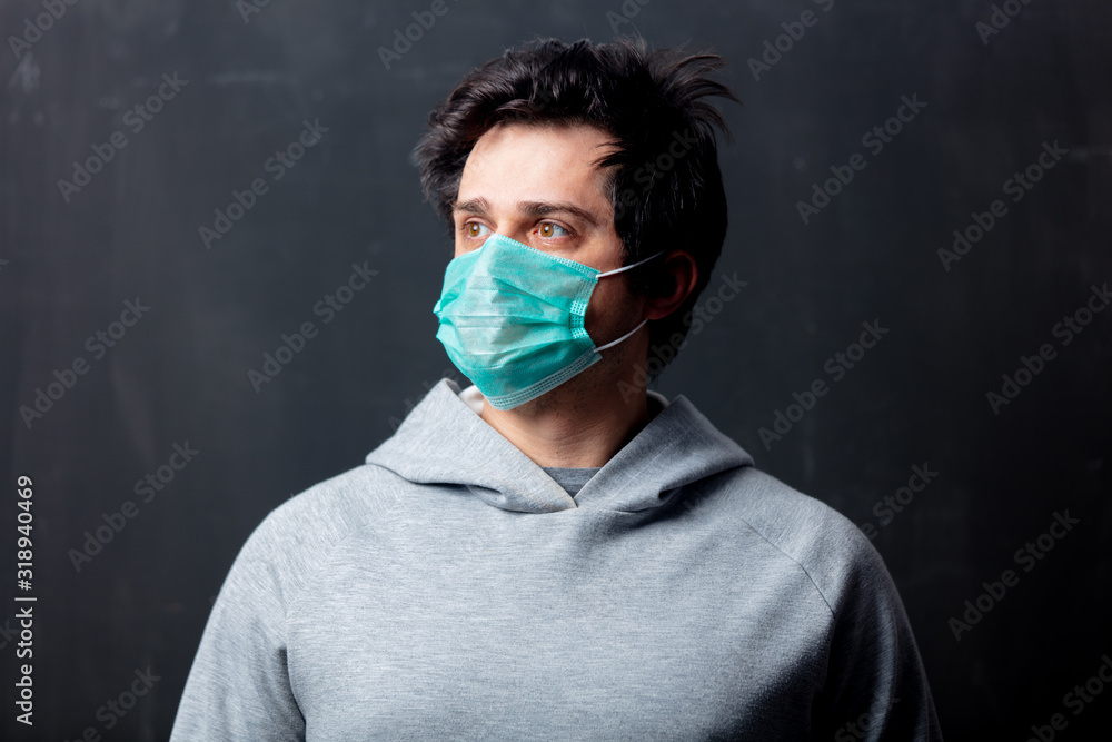 young white man in protective mask on dark background young white man in protective mask on dark background