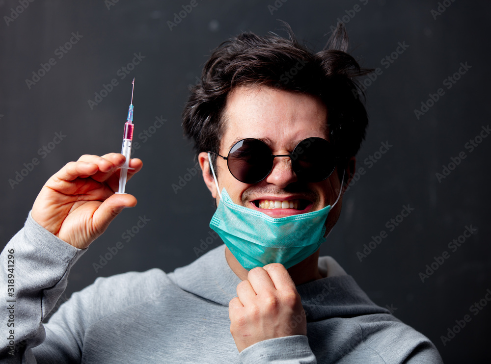 young white man in protective mask and sunglasses with syringe vaccine young white man in protective mask and sunglasses with syringe vaccine