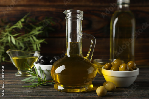 Composition with olive oil and olives on wooden background, close up